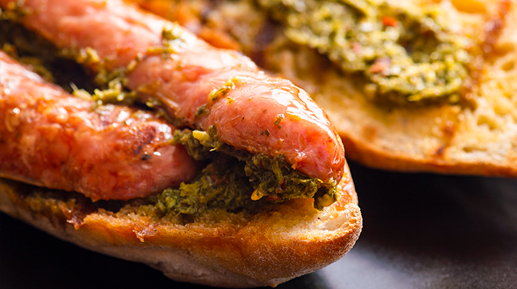 Destaque do choripán, sanduíche argentino com linguiça grelhada servida em um pão e molho chimichurri.