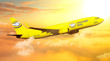 Avião da GOL amarelo e com o logotipo do Mercado Livre na lateral,voando sobre as núvens