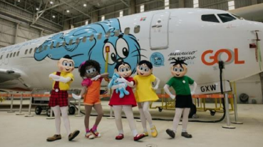 Personagens da Turma da Mônica pousando em frente a um avião GOL temático do desenho