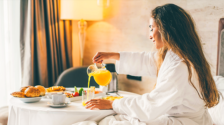 Mulher toma café da manhã no quarto de hotel na vila Morra, em Assunção