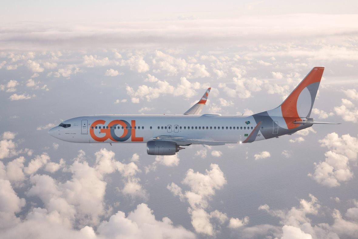 Imagem de um avião com o logo da GOL Linhas Aéreas em trajeto nas núvens