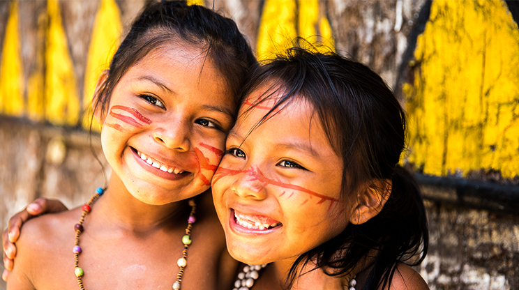 Crianças indígenas sorriem.