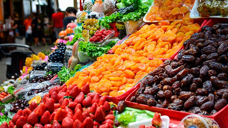 Banca de frutas do Mercado Municipal, com morangos, ameixas, damascos e uvas.