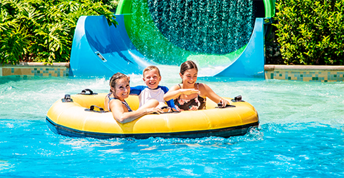 Três crianças dentro de uma boia redonda na piscina em um parque aquático de Orlando.