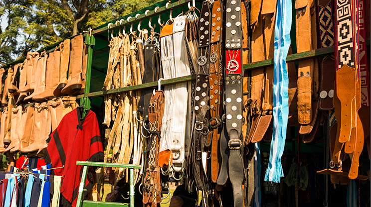 Barraca vendendo vários tipos de cintos de couro e artigos regionais.