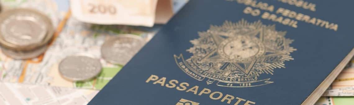 Documentos para embarcar Imagem de um mapa de ruas de uma cidade, e em cima dele um passaporte do Brasil e algumas moedas e notas de dinheiro.