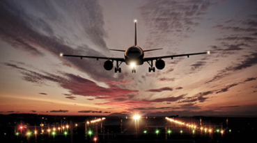 Avião comercial pousando na pista com dramático pôr-do-sol