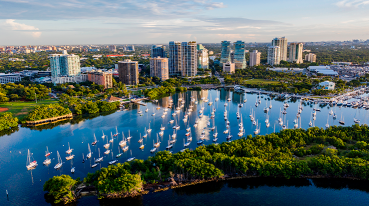 Vista panorâmica do bairro de Coconut Grove, com grandes empreendimentos residenciais, áreas verdes e embarcações na Baía de Biscayne.