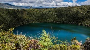Lagoa de Guatavita, com árvores e vegetação ao redor.