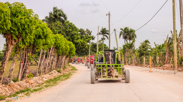 Estrada de terra batida em Punta Cana, com árvores ao redor, e uma fileira de buggys.